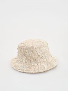 Ażurowy kapelusz bucket - kremowy. Białe kapelusze Reserved, w ażurowe wzory. Za 69,99 zł.