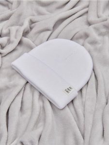Czapka beanie - kremowy. Białe czapki Sinsay, z aplikacjami, z dzianiny. Za 9,99 zł.