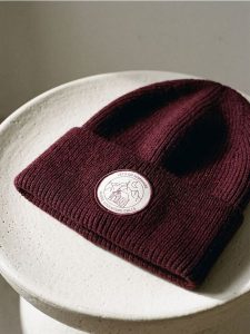 Prążkowana czapka beanie z naszywką - bordowy. Czerwone czapki Sinsay, z aplikacjami, prążkowane. Za 19,99 zł.