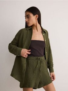 Koszula z bawełnianego muślinu - oliwkowy. Zielone koszule Reserved, l, bez wzorów, z bawełny, bez kołnierzyka, bez ramiączek. W wyprzedaży za 89,99 zł.