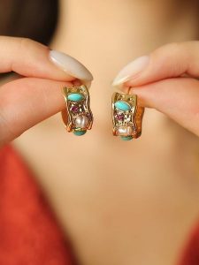 Pierres de Jade Pozłacane kolczyki-wkrętki z cyrkoniami i perłami rozmiar: onesize. Żółte kolczyki Pierres de Jade, z cyrkonią, pozłacane. Za 43,99 zł.