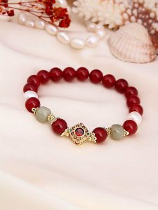 Pierres de Jade Pozłacana bransoletka z perłami i agatem rozmiar: onesize. Czerwone bransoletki Pierres de Jade, z agatem, pozłacane. Za 43,99 zł.