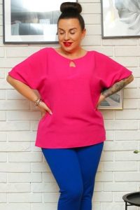 Bluzka na komunię z łezką lekka modna ELIDA amarantowa. Czerwone bluzki KARKO, plus size, bez wzorów, z dzianiny, biznesowe, bez kołnierzyka, plus size, bez ramiączek. Za 59,50 zł.