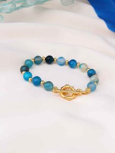 Pierres de Jade Pozłacana bransoletka z elementami ozdobnymi rozmiar: onesize. Niebieskie bransoletki Pierres de Jade, z agatem, pozłacane. Za 43,99 zł.