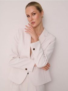 Klasyczny żakiet zapinany na guzik - kremowy. Białe marynarki i żakiety Sinsay, l, bez wzorów, klasyczne. Za 69,99 zł.