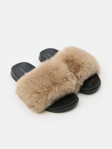 Klapki z futerkiem - kremowy. Białe klapki Sinsay, bez wzorów, bez obcasa. Za 29,99 zł.