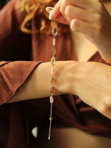 Pierres delicates Pozłacana bransoletka z cyrkoniami i perłami rozmiar: onesize. Brązowe bransoletki Pierres delicates, z cyrkonią, pozłacane. Za 78,99 zł.