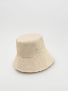 Kapelusz bucket z haftowanym napisem - złamana biel. Kapelusze Reserved, bez wzorów. Za 59,99 zł.