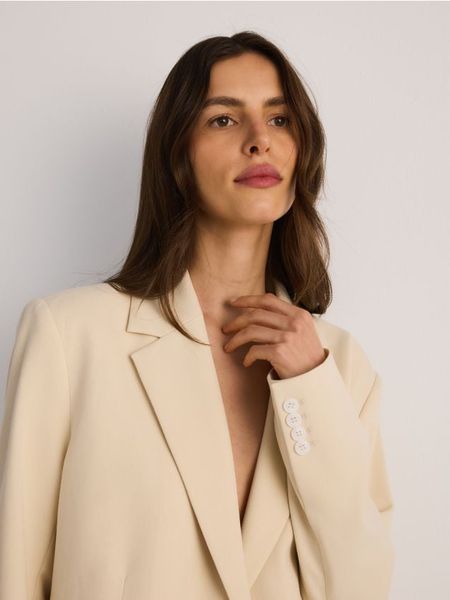 Jednorzędowa marynarka oversize - złamana biel. Marynarki i żakiety Reserved, l, bez wzorów, z tkaniny. W wyprzedaży za 119,99 zł.