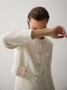 Krótki żakiet z tkaniny boucle - złamana biel. Marynarki i żakiety Reserved, l, bez wzorów, z bawełny. W wyprzedaży za 119,99 zł.