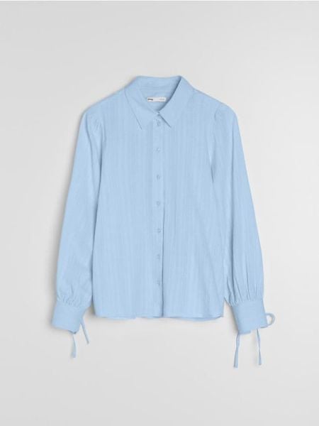 Bawełniana koszula z dekoracyjnym wiązaniem przy mankietach - błękitny. Niebieskie koszule Sinsay, l, bez wzorów, z bawełny, bez kołnierzyka, bez ramiączek. Za 49,99 zł.