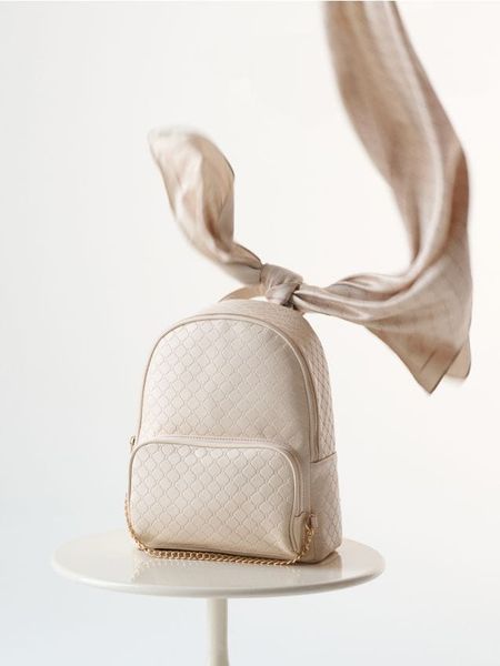 Plecak z pikowanym wzorem i złotym łańcuszkiem - kremowy. Białe plecaki Sinsay. Za 59,99 zł.