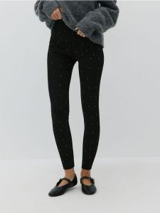 Legginsy z błyszczącymi aplikacjami - czarny. Czarne legginsy Reserved, z aplikacjami, z dzianiny. W wyprzedaży za 49,99 zł.