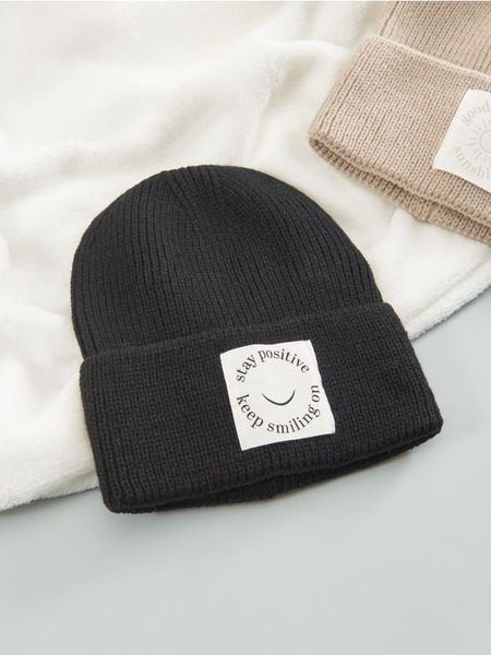 Czapka - czarny. Czarne czapki Sinsay, z aplikacjami, z materiału. Za 19,99 zł.