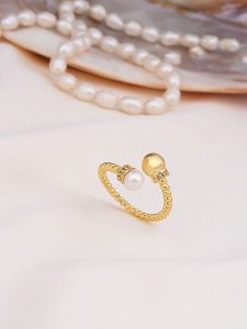 Pierres de Jade Pozłacany pierścionek z perłami i cyrkoniami rozmiar: onesize. Białe pierścionki Pierres de Jade, z cyrkonią, pozłacane. Za 39,99 zł.