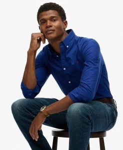 Superdry Klasyczna koszula Oxford z długim rękawem z bawełny organicznej. Niebieskie koszule Superdry, l, bez wzorów, z bawełny, bez kołnierzyka, bez ramiączek. Za 314,00 zł.