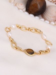 L'Atelier de Gaia Pozłacana bransoletka z tygrysim okiem i perłami rozmiar: onesize. Białe bransoletki L'Atelier de Gaia, z perłą, pozłacane. Za 73,99 zł.