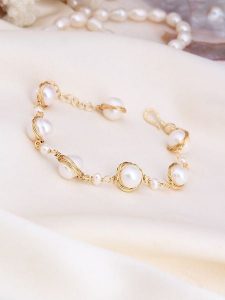 L'Atelier de Gaia Pozłacana bransoletka z perłami rozmiar: onesize. Białe bransoletki L'Atelier de Gaia, z perłą, pozłacane. Za 130,99 zł.