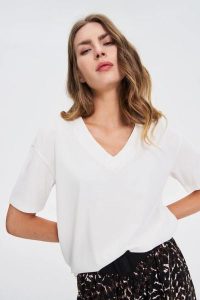 T-shirt z dekoltem w serek biały. Białe t-shirty MOODO, l, bez wzorów, z bawełny, bez kołnierzyka, bez ramiączek. Za 39,99 zł.