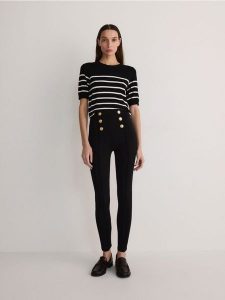Legginsy z ozdobnymi guzikami - czarny. Czarne legginsy Reserved, bez wzorów, z dzianiny. W wyprzedaży za 39,99 zł.